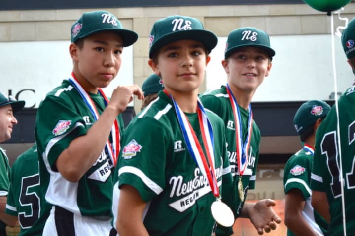 Members of the Westport 12U All Stars Little League team look out at the crowds gathered on Main Street during Monday&#x27;s parade.