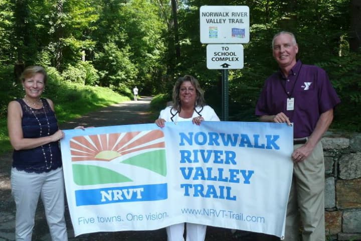 Patricia Sesto, NRVT Chairperson; Carol Johnson, Wilton Alliance for a Healthy Community Co-Chair; Bob McDowell, Executive Director of the Wilton Family Y stand near the Wilton portion of the Norwalk River Valley Trail.