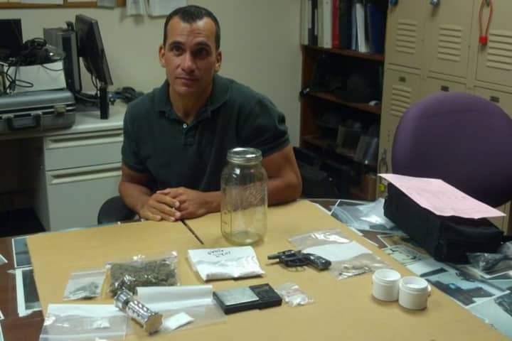 Sgt. Richard Gasparino shows off the cocaine, marijuana, revolver, and other items seized during a drug rain in Stamford&#x27;s Cove neighborhood. 