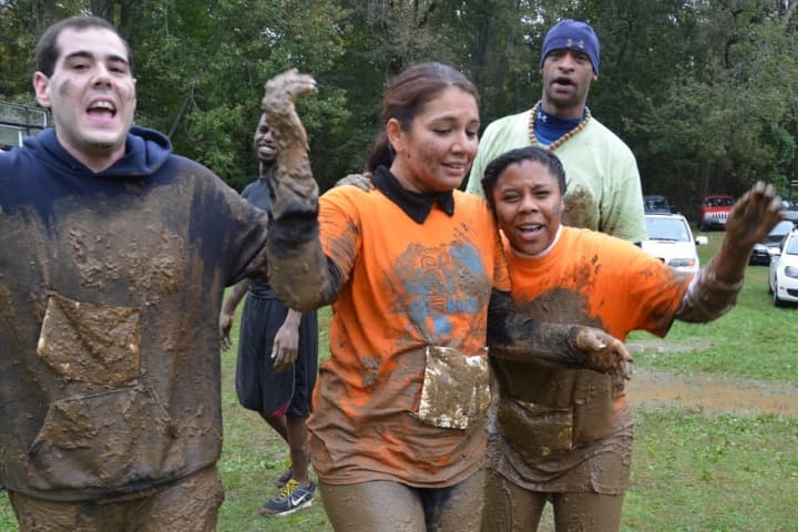 Rocco Natale of Greenwich, left, Lisa Maldonado, center, and Takeia McAlister of Stamford finish the Muddy Up race last year.