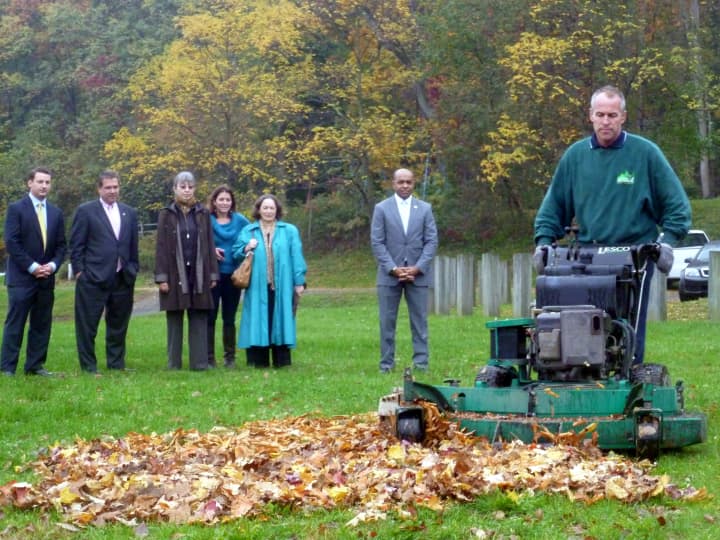 Tim Downey, owner of Aesthetic Landscape Care Inc., shows city officials how leaf mulching works in Redmond Park in Yonkers.