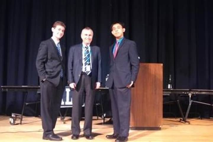 Blind Brook High School students Samuel Zarkower and Stanley Vuong pose with Superintendent of Schools William Stark following the Friday debate.