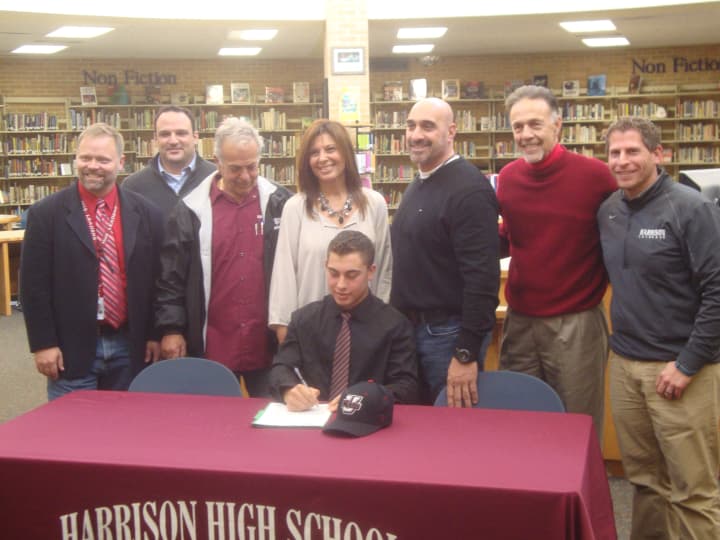 Harrison High School senior Jake Marino, surrounded by family and coaches, signs his letter of intent.