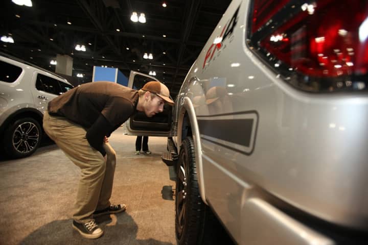A visitor to the Connecticut International Auto Show in 2012 inspects a vehicle.
