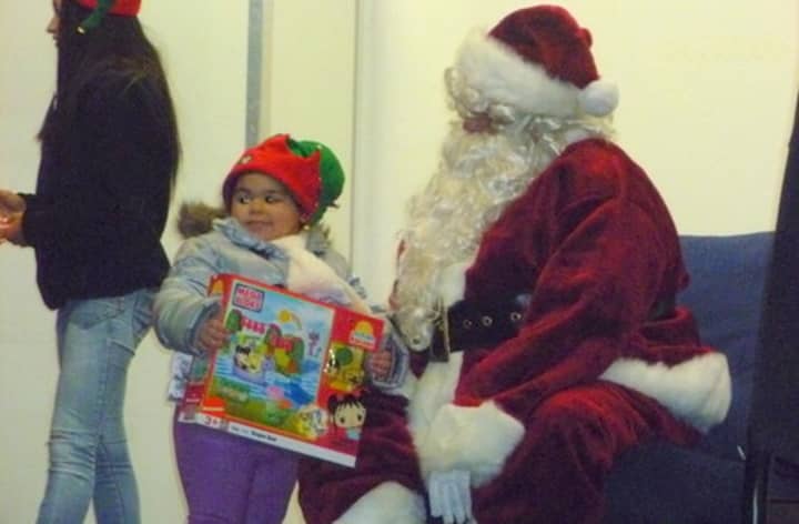 Santa hands out gifts to children during a previous visit to Port Chester. 