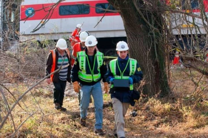 NTSB officials retrieve an event recorder from the derailed Metro-North train in the Bronx. Photo 