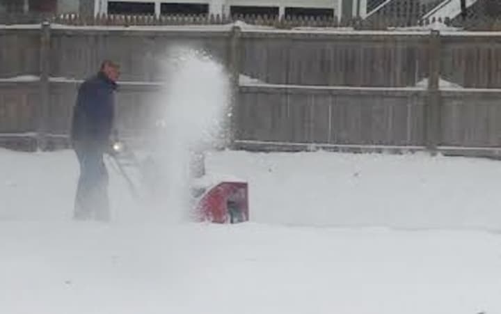 A Danbury resident tackles a long driveway off Deer Hill Avenue with a snowblower on Sunday morning. 