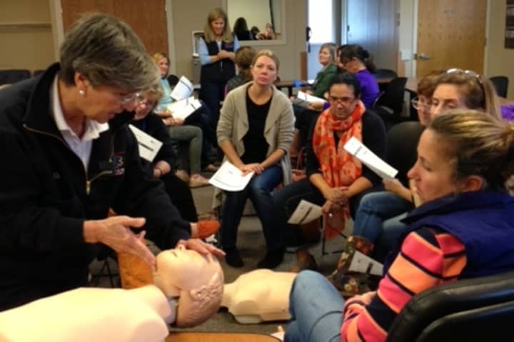 Joan Gildea, Darien EMS-Post 53 adult adviser and CPR director, (left, in EMT jacket), teaches staff from Playdates Preschool in CPR, AED and First Aid.