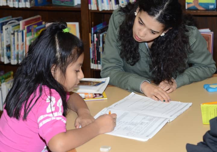  Jenny Guaman (age 8), and Kimberly Rosario, a senior at Purchase College at the Port Chester-Rye Brook Public Library.