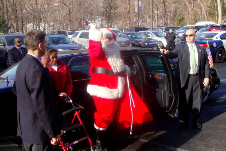 Santa Claus, protected by U.S. Secret Service agents, steps out of a presidential limo at Arc of Westchester in Hawthorne.