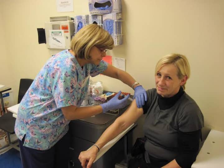 A volunteer gives a flu shot to a patient at the CommunityHealth clinic in the West Town neighborhood of Chicago. CommunityHealth received 1,000 doses of flu vaccine from AmeriCares.