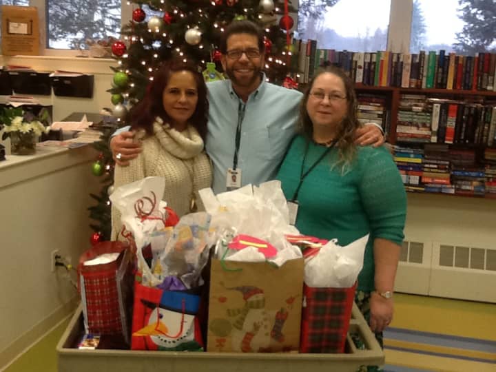 From left-Alda Gomez, Richard Schaeffer and Judi Jehler accept holiday gifts for their Somers Manor residents.