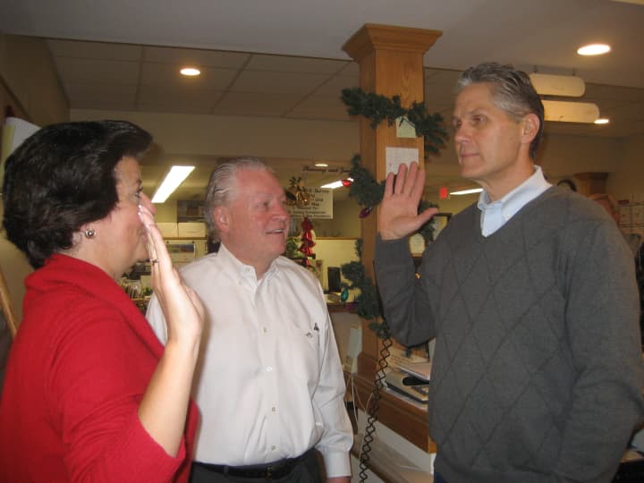 Fairfield Town Clerk Betsy Browne swears in Thomas Conley while First Selectman Mike Tetreau looks on.