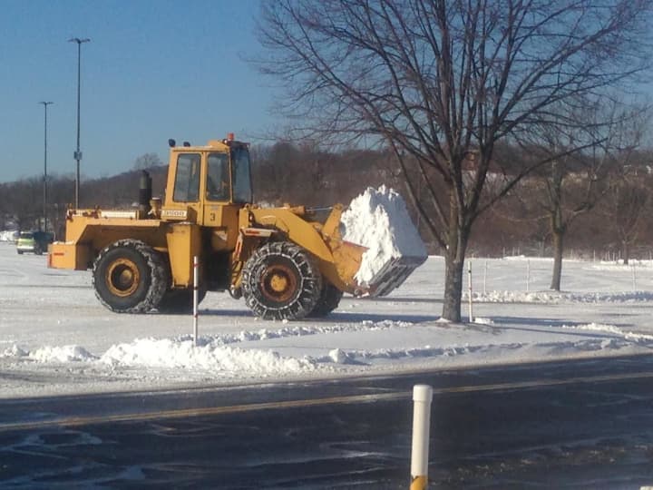 A payloader clears snow from the parking lot at the Danbury Fair Mall. 
