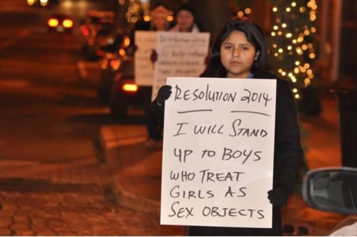 Norwalk Center for Youth Leadership member Mirella Fernandez holds up a sign on New Year&#x27;s Eve. 