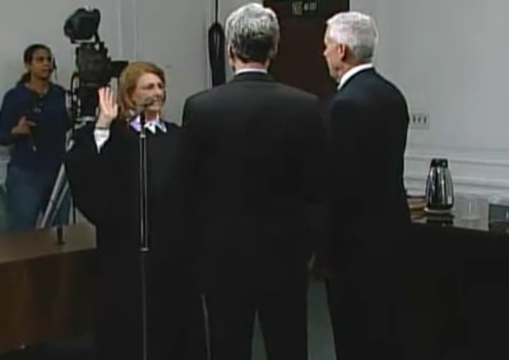 Mayor Thomas Roach joins John Martin as he is sworn in as Common Council president by Judge Jo Ann Friia.