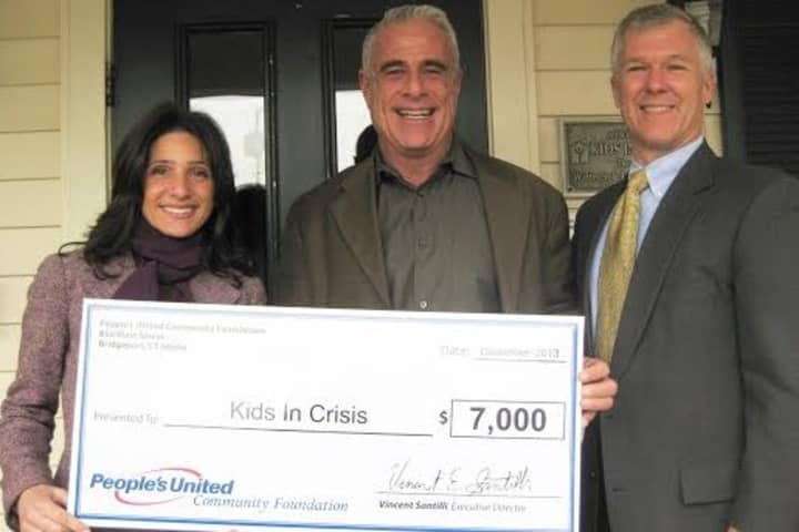 Alon Marom, Director of Development, Corporate and Community Giving for Kids in Crisis (center) accepts the chck from Karen Galbo and Michael Keady.
