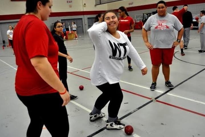 Sacred Heart University women&#x27;s track &amp; field team co-captain Lindsay Aponte, left, works with Blackham School students during a recent throwing clinic in the Pitt Center. Fellow team member Kolbi Smith, right, looks on. 