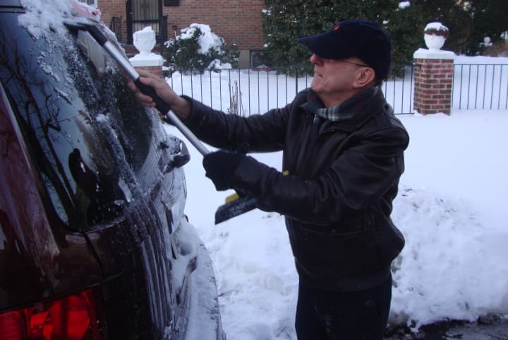 Michael Immediato of Harrison scrapes ice off of his car.