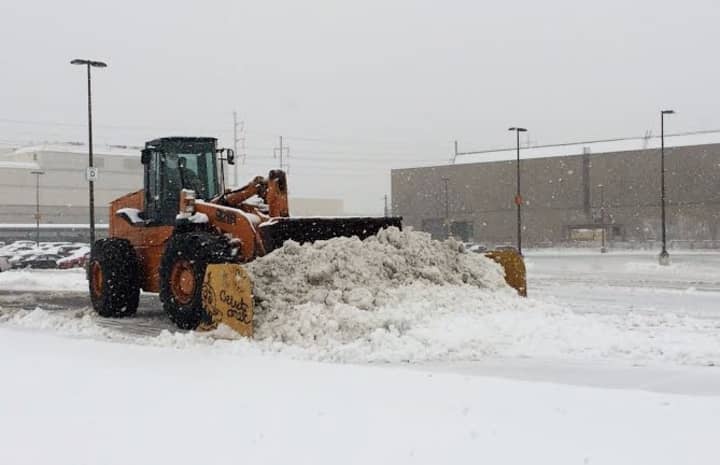 A front-end loader pushes the snow around Monday afternoon at the Fairfield Metro train station. 