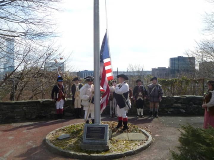 Washington era re-enactors raise the American flag at the White Plains Presidents Day celebration in 2013.
