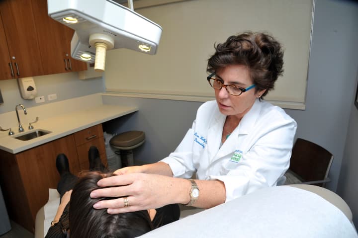 White Plains Hospital dermatologist Lesa Kelly, M.D. examining a patient in her office in New Rochelle.
