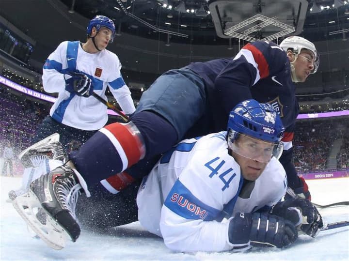 Ryan McDonagh, #27, of the United States falls on Kimmo Timonen, #44, of Finland in the first period of the Bronze Medal game Saturday at the Sochi Olympics.