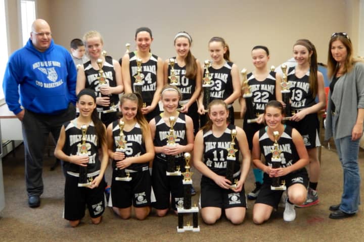 The Holy Name of Mary eight grade girls basketball team from Croton poses with its championship trophies. Player names are in the body of the story.