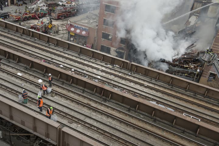 Crews clear debris on Metro-North tracks adjacent to scene of a building collapse at 116th Street and Park Avenue in East Harlem. 