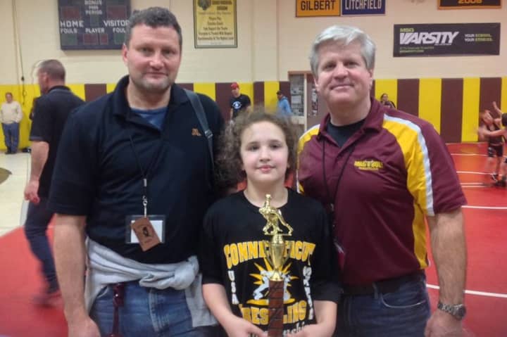 Norwalk Mad Bulls wrestler Anna Haus won a state title on Sunday. She is with her father Randy, left, and Art Schad, her coaches with the Norwalk Mad Bulls.
