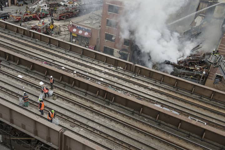 MTA crews clear the tracks in Harlem after Wednesday&#x27;s explosion in order to resume Metro-North train service. 