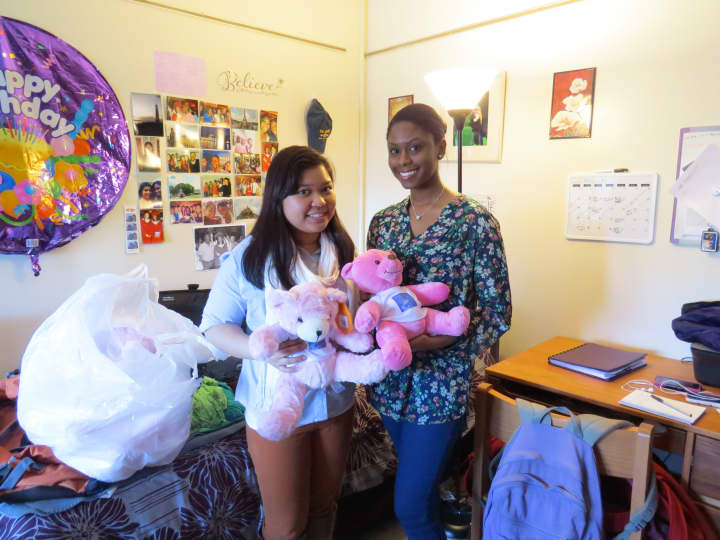 College of New Rochelle students Marie Gomez and Raisa Jadotte show off the bears they will give to Haitian children.