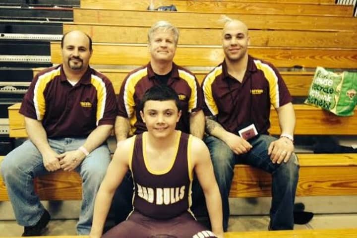 Norwalk Mad Bulls wrestler Jeff Cocchia, a New England champion, sits with coaches Dave Slapin, Art Schad and Jason Singer.