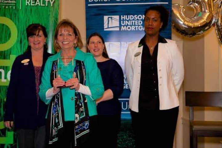 Janet Farsetta, vice president  of Relocation and Referrals Services of Better Homes and Gardens Rand Realty, accepts the award with Yvonne Regan, Erin Chambers and Monica Cooper.