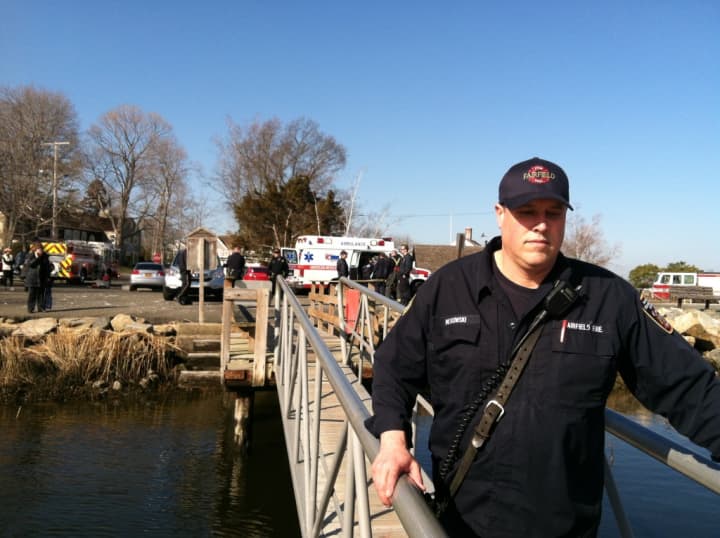 Firefighter Dave Mitkowski with Fairfield Fire Department, Fairfield Police Department and AMR units in background at marine rescue.