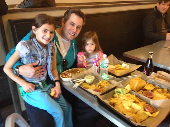 Josh Salles, of Larchmont, eats lunch with his daughters and wife (not pictured). 
