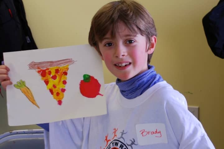 Brady Sullivan proudly holds up his painting created at the February Painting Workshop at the YWCA Darien/Norwalk.