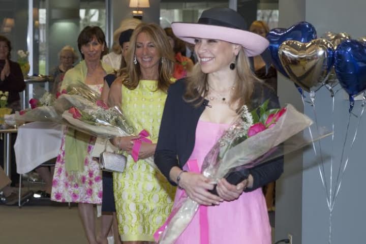Monica Hoyos of Cos Cob in pink hat and Kathy Muir of Greenwich in flowered dress take the catwalk at Greenwich Hospital&#x27;s fashion show.