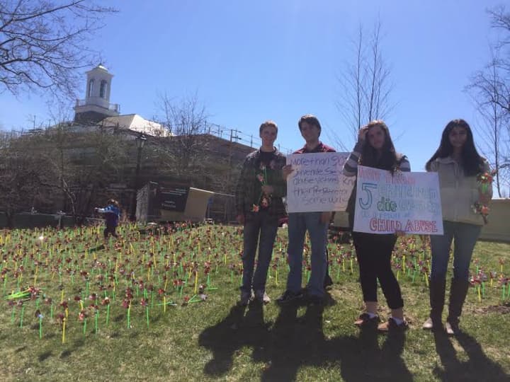 New Canaan High School students placed more than 1,800 pinwheels on the lawn of Vine Cottage to raise awareness of child abuse and neglect. 