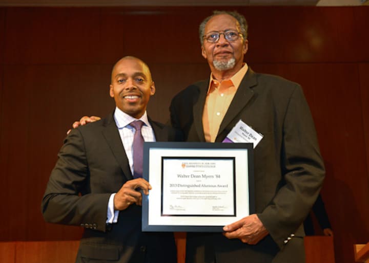 Khalil Gibran Muhammad, left, director of The Schomburg Center for Research in Black Culture, a research unit of The New York Public Library, presents Walter Dean Myers with the 2013 Distinguished Alumni Award.