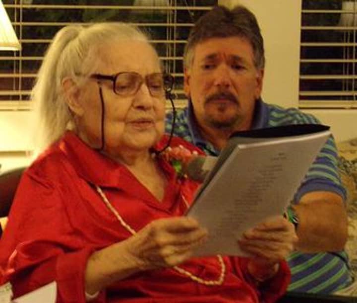 The Country House resident Diana Terry reads her story of a lifetime as Activities Director Paul Raigaud listens. 