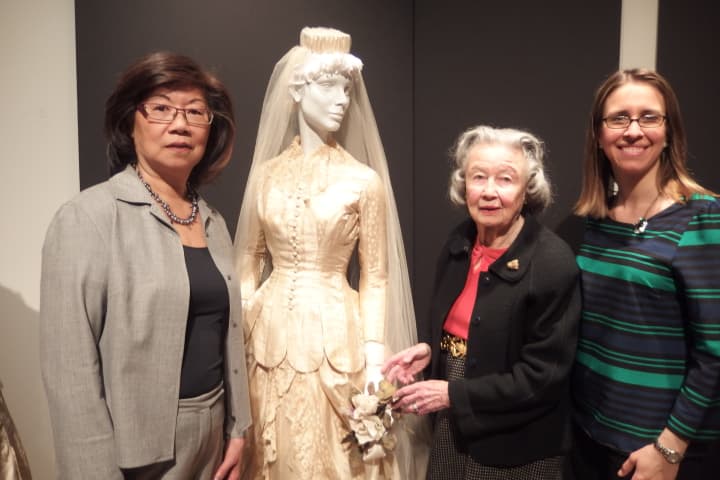 Kaye Leong, Darien Rowayton Bank; left, Babs White, Curator; center,  and Ashley Krauss, A Little Something White Bridal Couture get ready for the exhibit at the Darien Historical Society.