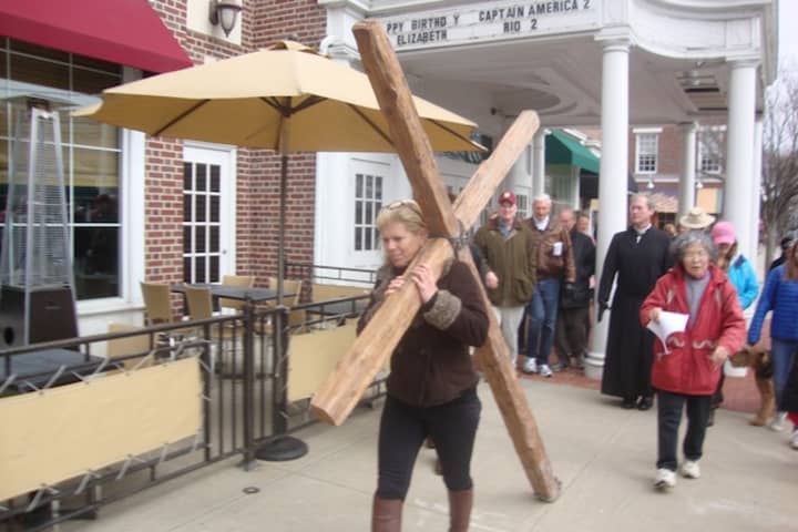 Members of several Darien churches carry a large wooden cross through the downtown area to commemorate Good Friday.