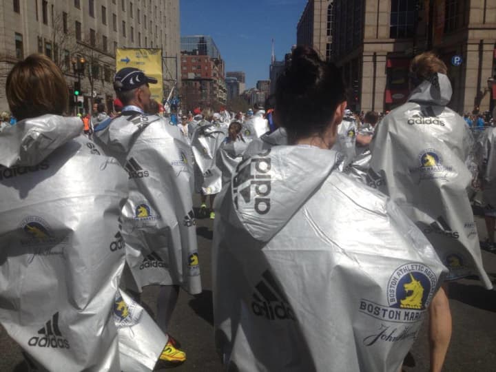 Runners in Monday&#x27;s Boston Marathon wrap up in foil sheets at the finish line.