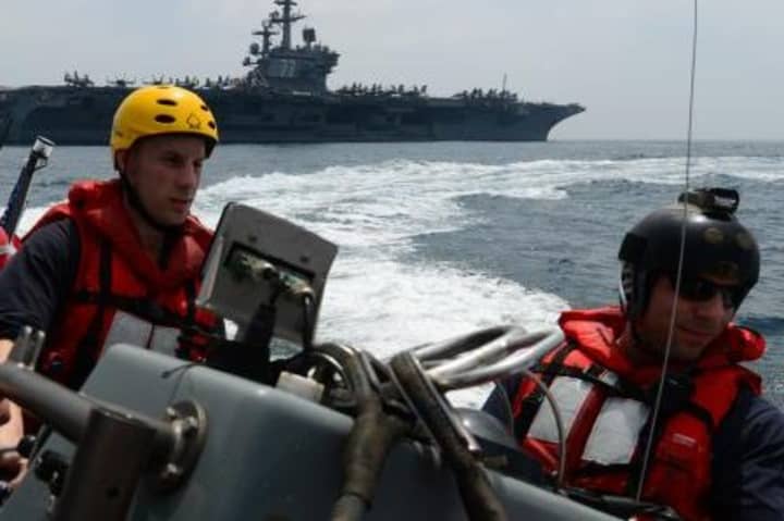 U.S. Navy Ensign Luke Paterna, right, of Norwalk and Boatswain&#x27;s Mate 2nd Class Ryan Wetzel work in small boat operations.