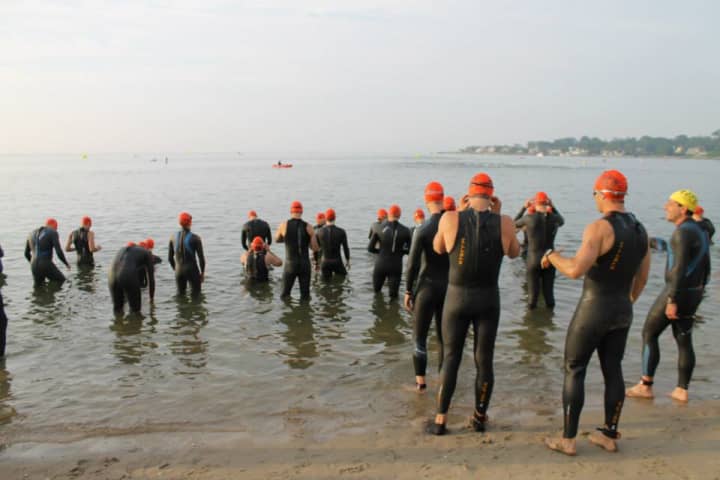 Swimmers enter the water at Cummings Beach for the Stamford KIC It triathlon in 2013.