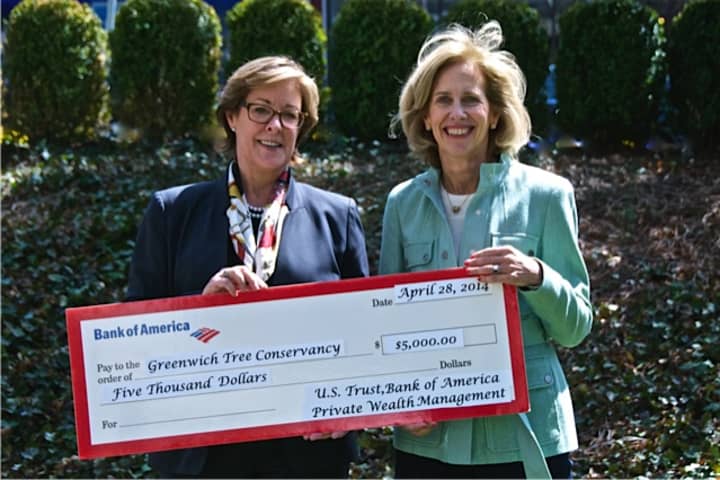 Marion Schmeelk of U.S Trust, Bank of America, hands a sponsorship check for the Greenwich Tree Conservancys Tree Party to Libby King, co-chairwoman of the Tree Party. 