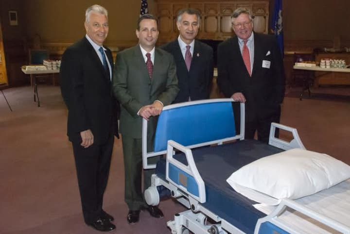 Sen. Carlo Leone and Sen. Bob Duff pose with executives of Norwalk-based Next Health Inc., whose new integrated hospital bed and wheelchair/commode system is helping patients stay in their homes.