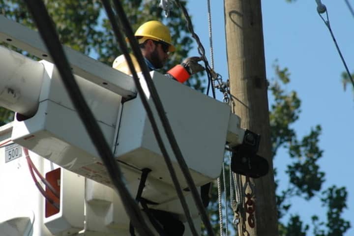 A CL&amp;P lineman reconnects a power line in Norwalk after Hurricane Irene.