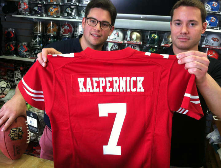 Mark Bisanzo, left, owner of Bruce Park Sports, and Nick Chapar, assistant manager, hold a Colin Kaepernick jersey. Bisanzo said he will wait to see if gay NFL rookie Michael Sam makes his team before deciding whether he will stock the jersey.